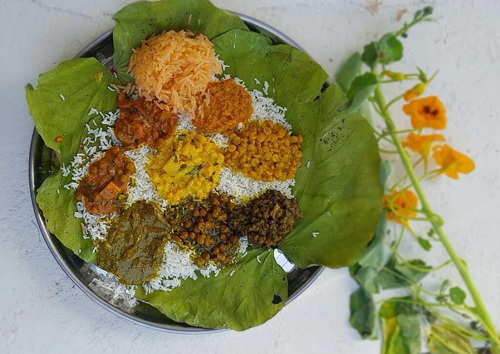 Authentic Himachali Dham feast with traditional dishes served on leaf plates in Himachal Pradesh